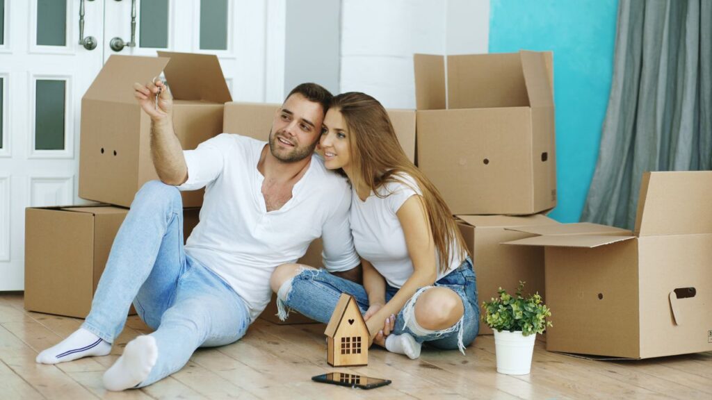Young couple celebrating their new home with unpacked boxes around.